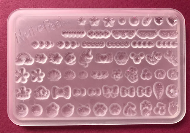 A plastic tray with lots of little shapes which can be moulded including bows, shells and hearts