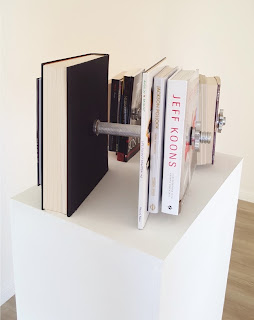 Silver chrome Barbell with books; Jeff Koons, Nicolas Machiavelli, Friedrich Nietzsche, Diogenes of Sinope, Sun Tzu, Baruch Spinoza, Socrates, Pascal ,Aristotle, Voltaire, Platon and Pablo Picasso, Andy Warlhol, Ai Weiwei,Jackson Pollock, Jean-Michel Basquiat.