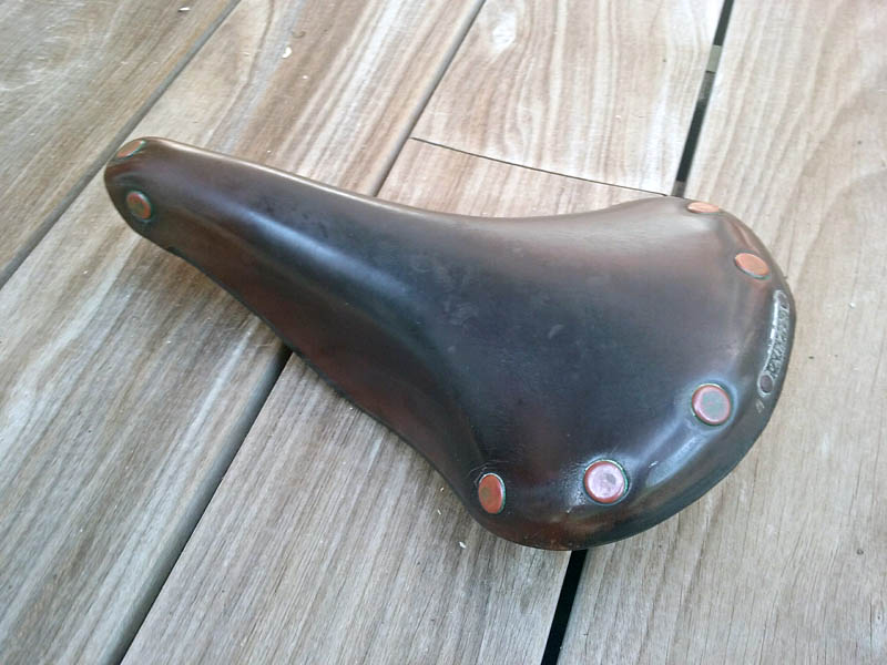 Brooks leather bicycle seat sitting on wood background