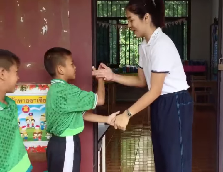 Teacher earns praise for greeting children with special handshake before class