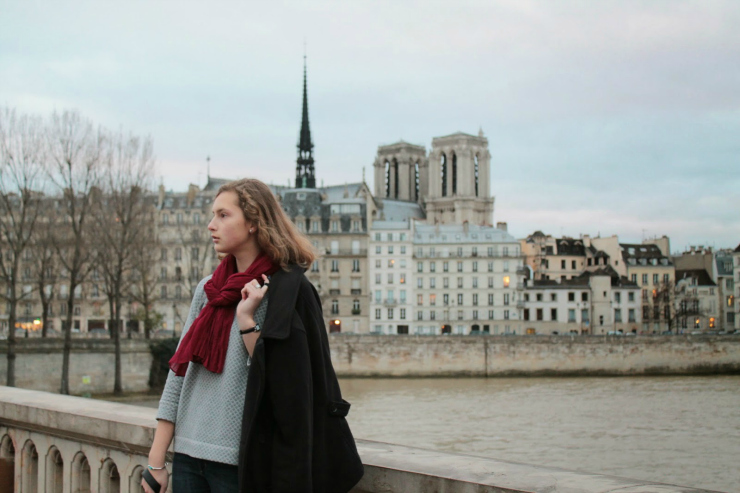 Parisian style of black pea coat, fashionable sweatshirt and jeans with a black leather bag