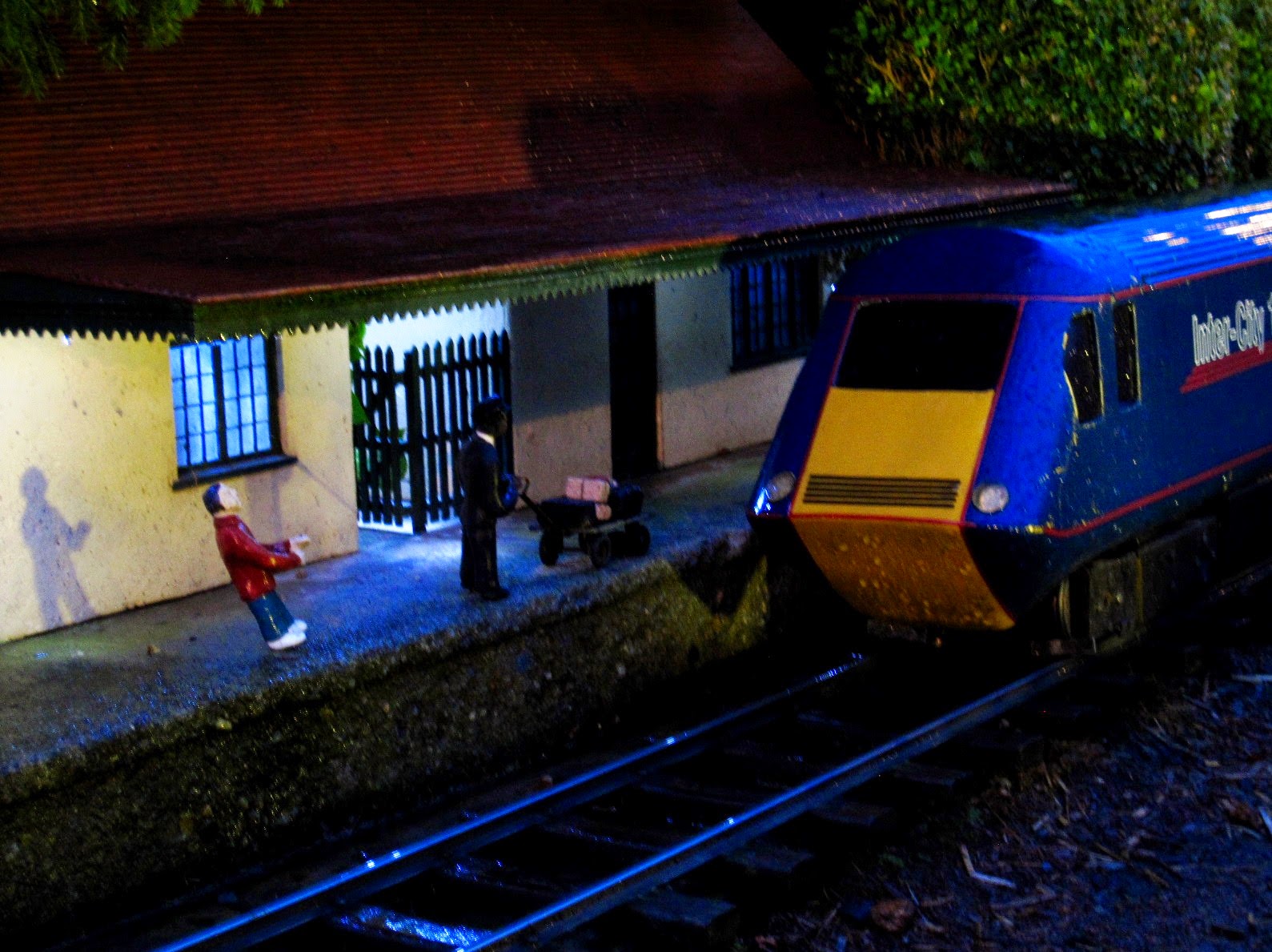 Miniature model of a railways station with a train at the station, at night.
