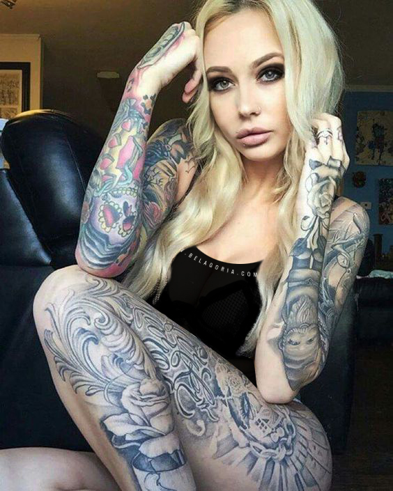Foto de una mujer rubia muy sensual, lleva tatuajes en brazos, y en piernas