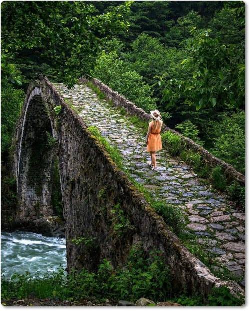 Ponte de pedra, por entre as árvores, sobre ela uma jovem caminhando solitária. Se você conhece o autor desta imagem, por favor nos informe para que possamos atribuir-lhe os devidos créditos. Obrigado. Ponte de pedra, por entre as árvores, sobre ela uma jovem caminhando solitária.