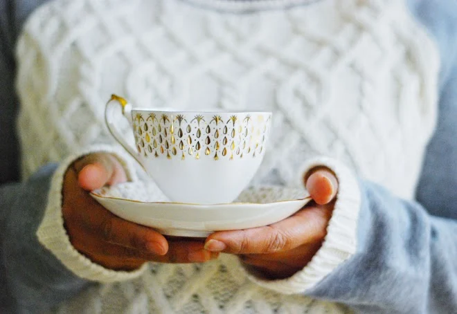 Vintage gold white tea cup in hand