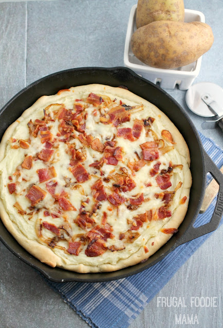 A thick, deep dish homemade crust is smothered in creamy homemade mashed potatoes, sweet caramelized onions, crispy bacon, and gooey cheese in this Deep Dish Pierogi Pizza.