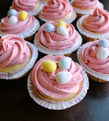 cupcakes with swirls of strawberry buttercream and mini chocolate eggs on top