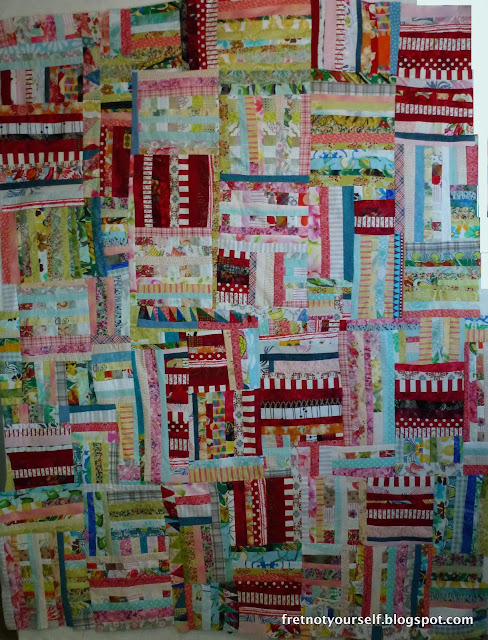 Improvisational Rail Fence quilt in red, green, blue and pink