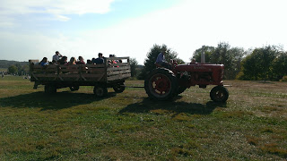 a tractor pulling a cart full of people on a hay ride