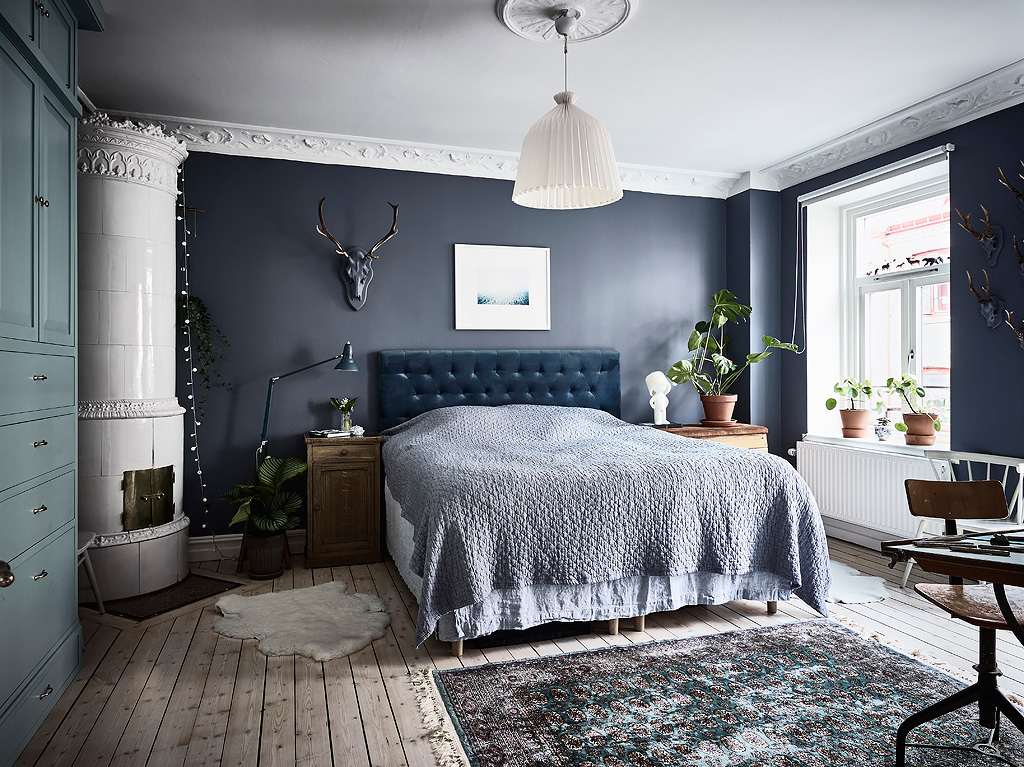 bohemian artist home scandinavian apartment  with houseplants wall art fireplace blue walls, bedroom