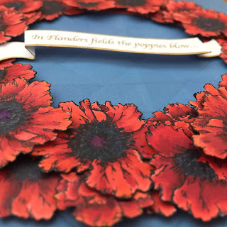 3D detail of banner, which says "In Flanders Fields the poppies blow"