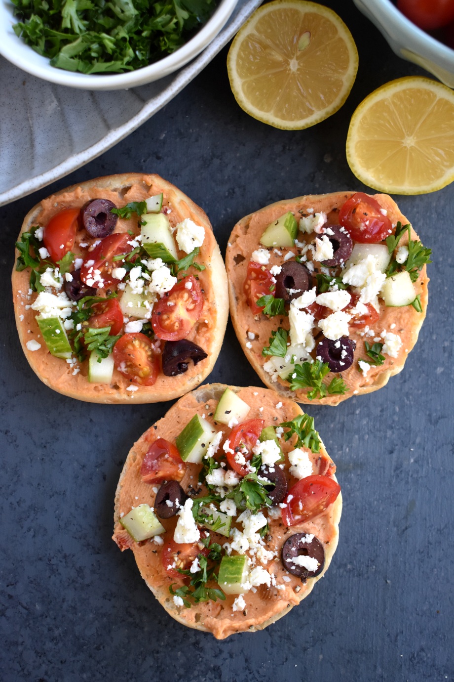 Mediterranean Hummus Bites are loaded with red pepper hummus, kalamata olives, tomatoes, cucumber and feta cheese on a toasted English muffin for an easy appetizer ready in 10 minutes that everyone will love! www.nutritionistreviews.com #healthy #appetizer #cleaneating #holidays