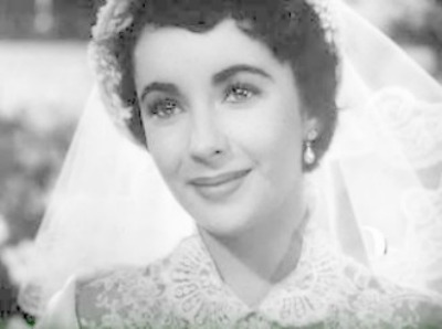 Smiling Elizabeth Taylor in bridal veil and dress in scene from Father of the Bride