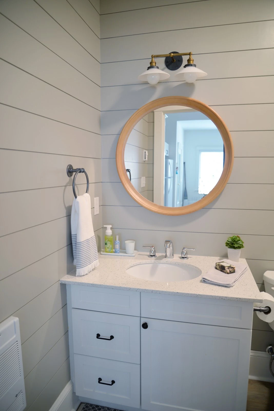 grey painted shiplap in the bathroom, round wood mirror, milk glass sconce | shiplap bathroom accent wall