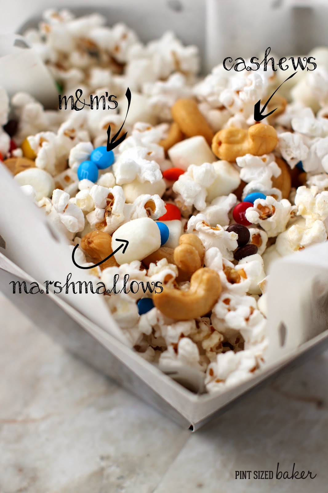 Popcorn mixed with Salty Cashews, Sweet mini marshmallows and M and M's and tossed with butter. A quick and easy snack!