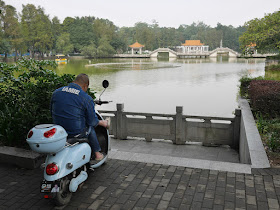 man sitting on a motor scooter and wearing an "IAMIE" jacket
