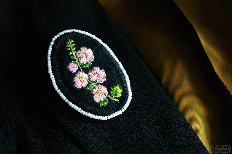 Sorgesmycke, broderad brosch med stockrosor och kant av vita glaspärlor. Av Alicia Sivertsson. aliciasivert alicia sivert sivertsson skapa skapande kreativitet diy do it yourself gör det själv creativity art konst textilkonst textile broderi embroidery needlework hoop art hand handbroderi handbroderad broderad brosch broscher blad löv växter växtgäris hantverk handarbete handgjord handgjort sorgesmycke sorg smycke smycken begravning stockros stockrosor vita glaspärlor medaljong rosa svart stjälkstygn schattérsöm plattsöm efterstygn pärlkant kantad av pärlor som tårar minne förlust avsked