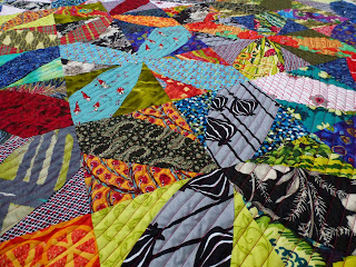 Multicolored fabrics are improvisationally cut to form windmill blocks.