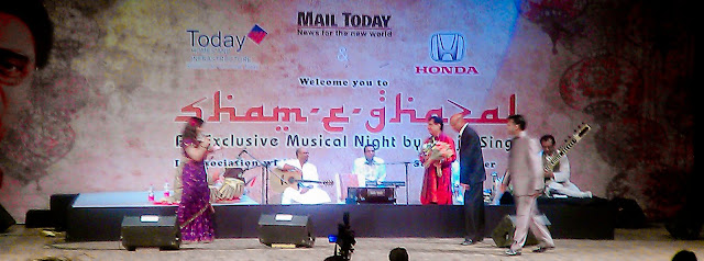 Mobile-giri at Sham-e-Ghazal with Jagjeet singh @ Sirifort Auditorium in Delhi (6th March 2011)  : posted by VJ SHARMA @ www.travellingcamera.com : Finally we got passes for today's Sham-e-Ghazal by Jagjeet Singh. We have been trying to see his live performance for last 6 years but we never managed to get tickets or invitation-Passes. This time, one of my friend arranged few passes for us and we had a lovely evening today ! Although it was but disappointing that cameras were not allowed inside :) ... but thanks to Adobe for gifting HTC Desire HD with nice Camera !!! So this was a good opportunity to try that in very low light conditions... Here are few photographs of Sham-e-Ghazal which are clicked with HTC Desire HD !!!HTC Desire provide various modes of clicking Photographs : Distortion, Vignette, Depth of Field, Sepia, Monochrome, Vintage, Vintage Warm, Vintage Cold, negative, Solarize, Polarize, Aqua !!!Photograph above is clicked using Sepia Mode and it was most suitable for Sham-e-Ghazal :)MAIL TODAY officials presenting flowers to Mr. Jagjeet Singh on his arrival at the stage !!!Mail Today organized Sham-e-Ghazal on 6th March at Sirifort Auditorium and it was planned to start at 6:00 pm... Plan was to close the gates by 5:45 pm and seat availability was on the basis of first come first serve !!! We reached at 5:15 pm and followed the queue.. I mean, started waiting for opening of gate !! There were very few folks at that time and people started coming. At 5:45 pm there were lot of Jagjeet fans in that queue...HONDA Officials presenting flowers to Mr. Jagjeet Singh !!!At 6:00 pm , gates were yet to be opened. It was bit surprising but there were no signs of opening the gates within next 15 mins.. There were two lines initially, one for men and other for women ! After 6:15 pm, few ladies came and started a new line. Other two lines were 300 meter long and people standing at the end started complaining about this third line. Security folks were very lazy and they didn't do anything even when many folks requested them to follow right practices. But no use !! Even people standing in third row were simply ignoring others.. All this didn't impact us because we were in the beginning of first two rows ! Manisha Dube introducing the man who don't need any introduction.. Mr. Jagjeet Singh !!!After standing for 2 hrs in a row, we got entry at 7:00 pm and program started at 7:40 pm !!! It was a great experience listening to Jagjeet Singh in Live show.. btw, we had VIP passes :) So he was very near to our seats !!! Wonderful performance by Jagjeet Singh and his troop of talented musicians !!!If you noticed these photographs, each has different effects and colors :) No editing, all are created in Camera only. HTC Desire HDIt was a good experience and want to Thank the friend who arranged passes for this event & Mail Today !!! But they need to be serious about the security and better planning !!