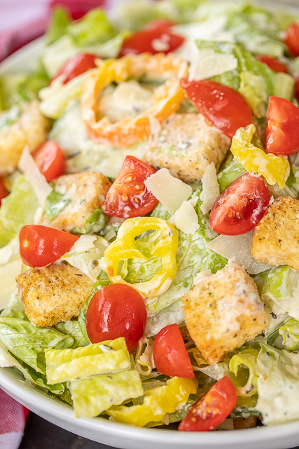 Creamy Italiano Salad - our favorite salad!!! Romaine, tomatoes, thinly sliced seedless cucumbers, sliced banana peppers, croutons and homemade Creamy Italiano dressing. The dressing really puts this salad over the top!!! Mayonnaise, red wine vinegar, milk, sugar, Italian seasoning, garlic, salt and pepper. I made this for a dinner party and everyone RAVED about it!! Give it a try for your next dinner party. You won't be disappointed! #salad #saladdressing #sidedish #vegetables #nobake Creamy Italiano Salad - our favorite salad!!! Romaine, tomatoes, thinly sliced seedless cucumbers, sliced banana peppers, croutons and homemade Creamy Italiano dressing. The dressing really puts this salad over the top!!! Mayonnaise, red wine vinegar, milk, sugar, Italian seasoning, garlic, salt and pepper. I made this for a dinner party and everyone RAVED about it!! Give it a try for your next dinner party. You won't be disappointed! #salad #saladdressing #sidedish #vegetables #nobake