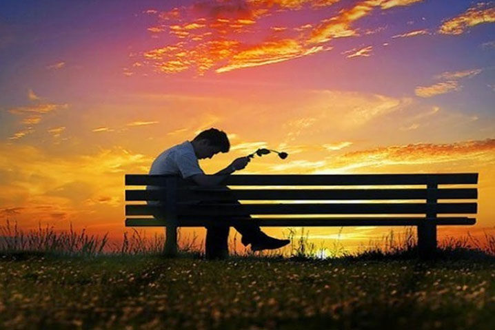 Hombres sentado en una banca sufriendo por desamor
