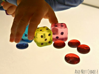 Using DIY jumbo dice on the light table for simple math problems from And Next Comes L