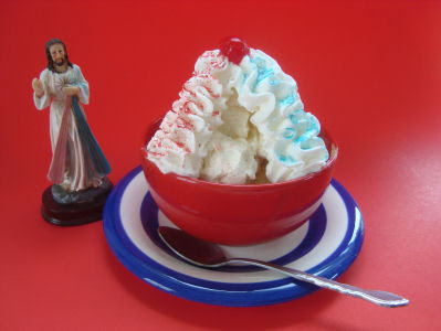 Sundae with cherry on top and two whipped cream lines one with red and one with blue sprinkles