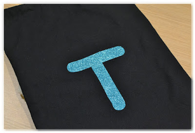 lettre T en flex à paillettes turquoises thermocollée sur tissu noir