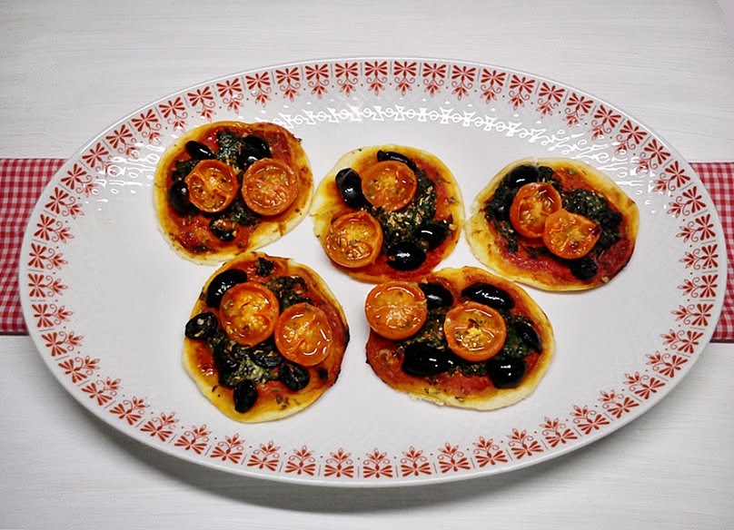 Mini pizzas de espinacas, tomatitos y aceitunas.