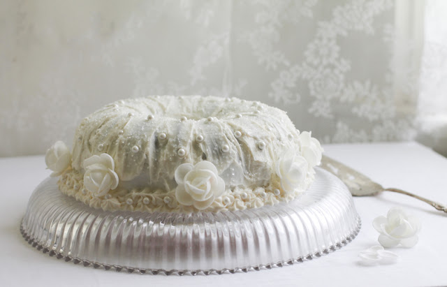Food Lust People Love: A simple one-bowl batter is the base of this beautiful almond wedding cake, decorated with almond buttercream icing and pearl and flower flourishes.