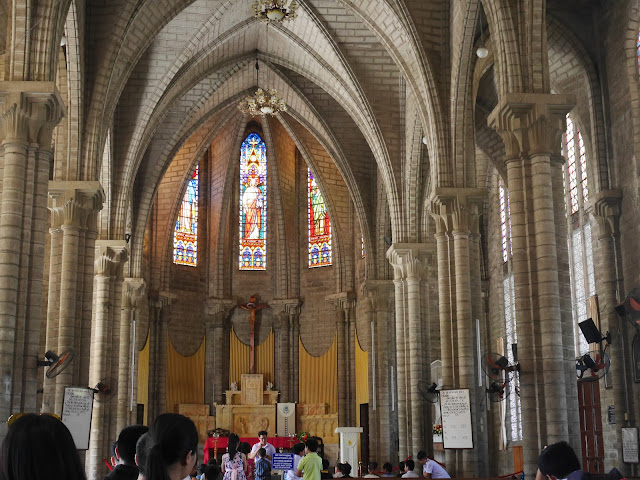 children receiving a blessing from a Catholic priest at Nha Trang Cathedral, Vietnam