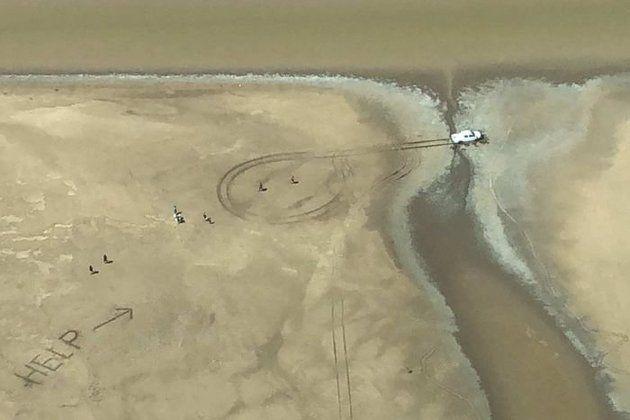 Señal enorme en la arena ayudó a rescatar a pareja varada en zona infestada de cocodrilos