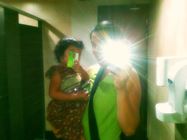 Mama & Kecil taking self photo in the restroom mirror