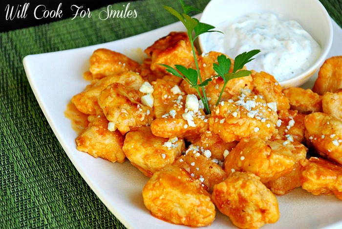 Boneless Buffalo Wings on a white plate with Homemade Ranch in a small bowl 