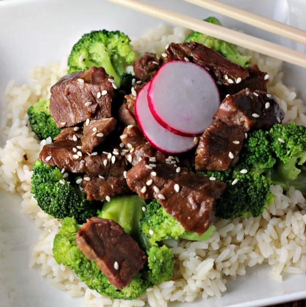Slow Cooker Beef and Broccoli on a white plate with chop sticks
