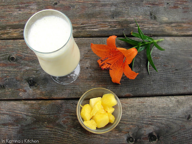 top down view of a smoothie, pineapple, and orange flower