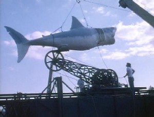 Fotograma de la película Tiburón (Jaws) que muestra una grúa de un barco que alza el cadáver del Tiburón asesino