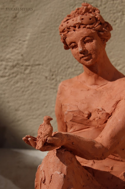 Woman with a Small Bird, Sarah Myers. Detail. woman, sculpture, art, bird, escultura, arte, terracotta, sarah, myers, red, clay, earthenware, sitting, seated, small, tanagra, classical, contemporary, kunst, skulptur, quick, lady, finch, graceful, close-up, detail, eye, hand