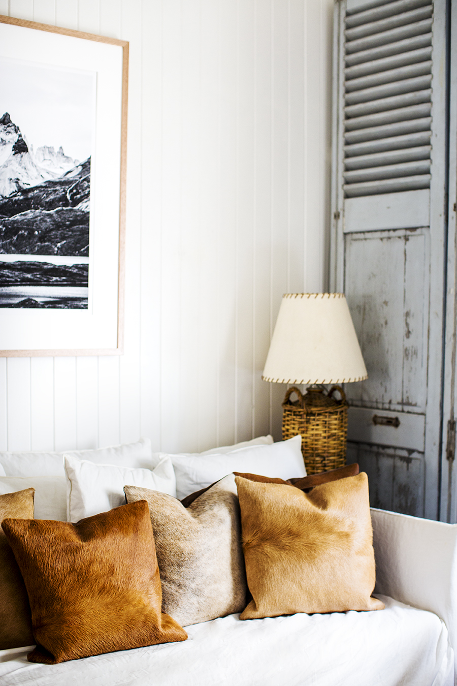 Rustic Bohemian Living Room Interior Design by Kara Rosenlund with white sofa and cowhide pillows. #rusticdecor #livingroom #texture #beachy #vintagestyle #interiordesign