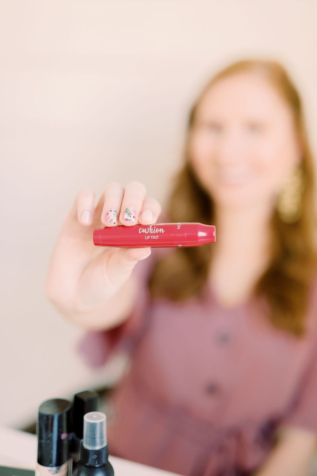 tampa blogger amanda burrows holding out the revlon kiss cushion lip tint in the color naughty mauve