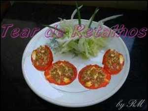 Tomates recheados com carne moída no prato complementado com salada de folhas verdes. Pronto para servir.