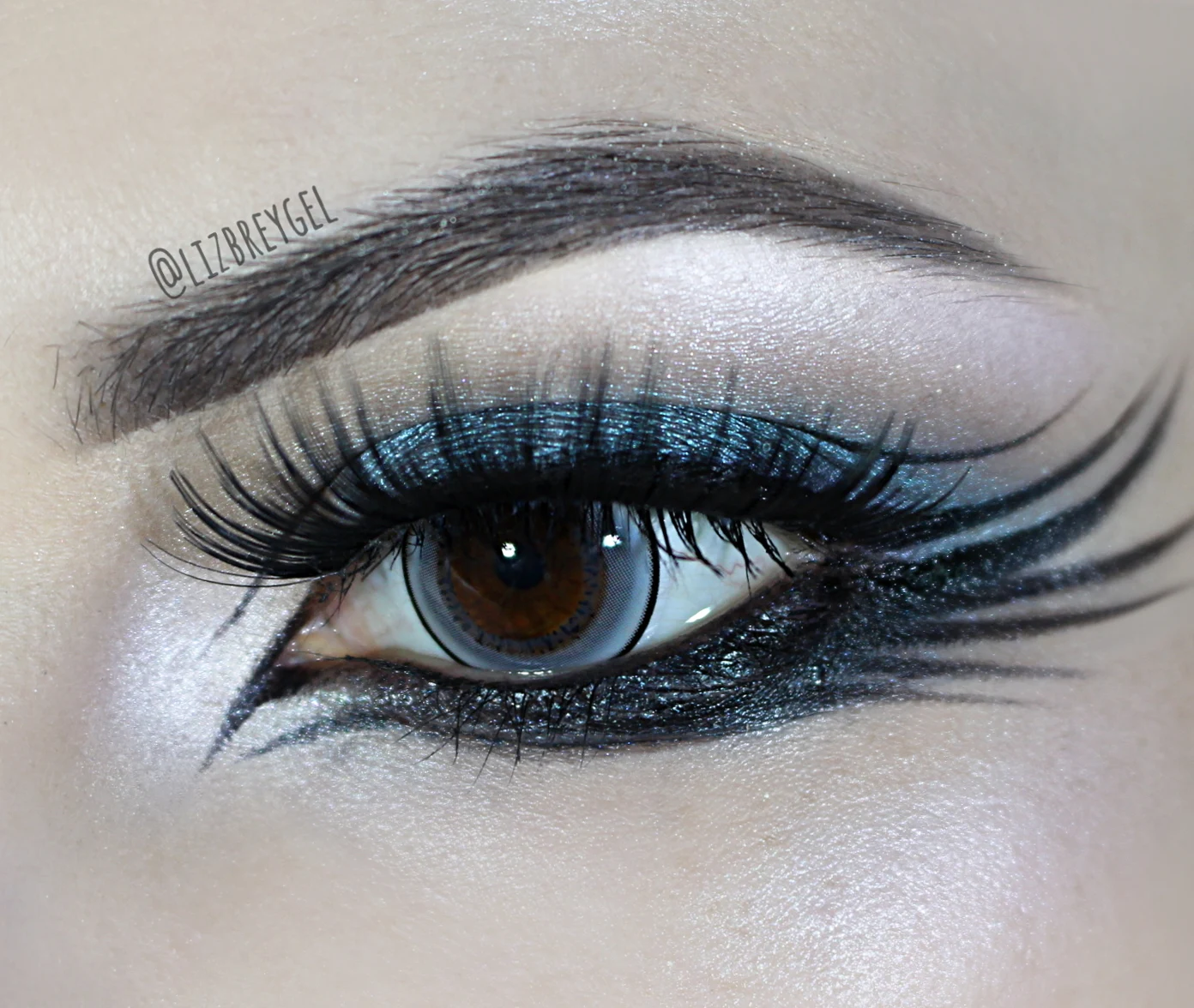 a close-up of an eye with an enlargind circle lens and a beautiful, gothic eye smokey look inspired by a raven wing