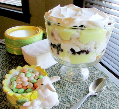 trifle bowl filled with layers of lemon goodness, angel food cake and blueberries topped with whipped cream