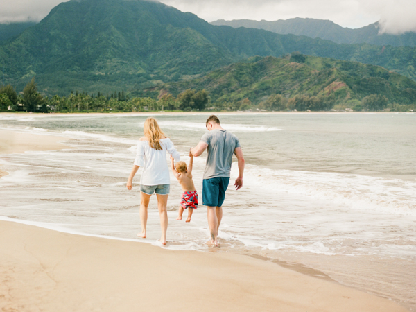 mom, dad & toddler plus the beautiful green mountains surrounding Hanalei Bay