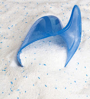 İçinde mavi partiküller olan bir toz deterjan ve ölçeği