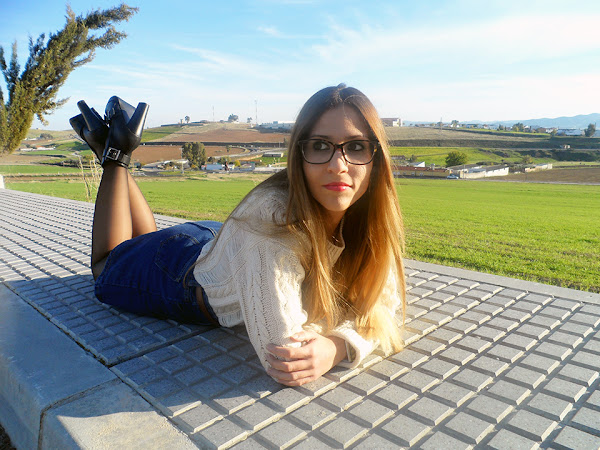 Falda denim acamapanda, jersey de punto rasgado, cazadora biker negra y botines de tacón con hebillas