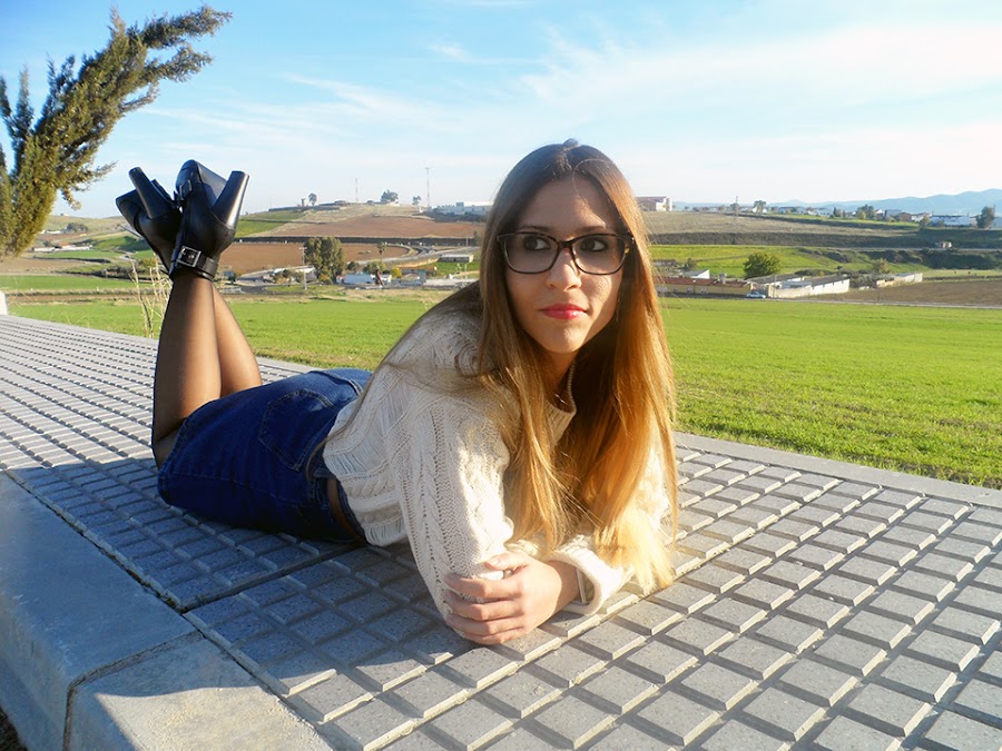 Falda denim acamapanda, jersey de punto rasgado, cazadora biker negra y botines de tacón con hebillas