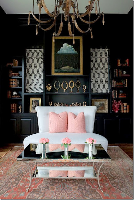 living area with black walls and pink pillows 
