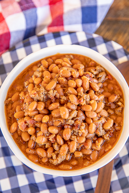 Instant Pot Baked Beans - seriously the BEST baked beans I've ever eaten!!! I could make a meal out of these yummy beans! Loaded with beef and bacon. SO easy to make! Great for potlucks and cookouts. Ground beef, bacon, onion, baked beans, ketchup, mustard, beef broth, garlic, brown sugar. I took these to a cookout and everyone asked for the recipe. A new favorite!! #instantpot #bakedbeans #cookout #sidedish baked beans with ground beef and bacon in a bowl