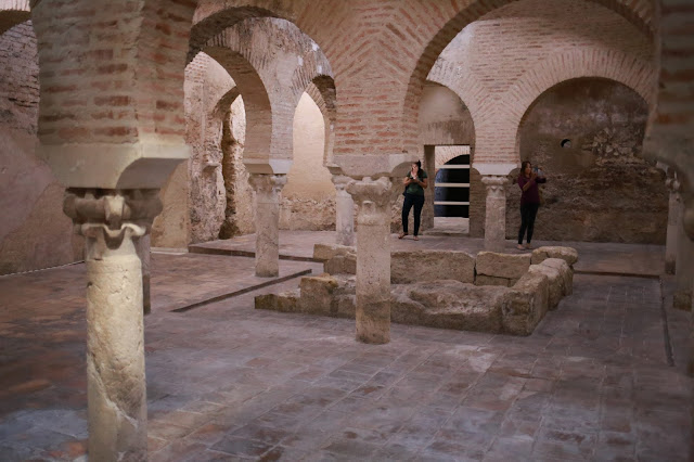 Interior de baños árabes antiguos con arcos de columnas y ladrillos.